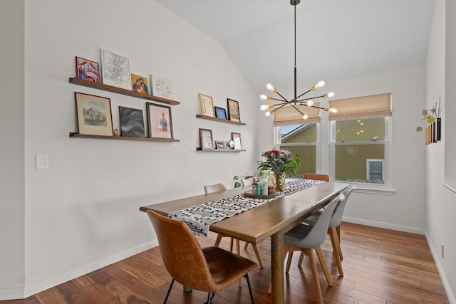 dining room with baseboards, hardwood / wood-style floors, and vaulted ceiling