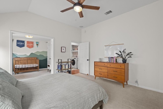 bedroom featuring visible vents, baseboards, lofted ceiling, light carpet, and washer / clothes dryer