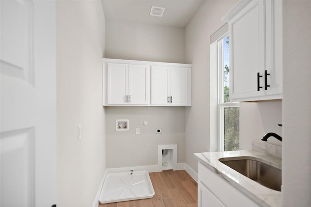 washroom with hookup for a washing machine, visible vents, hookup for an electric dryer, cabinet space, and a sink