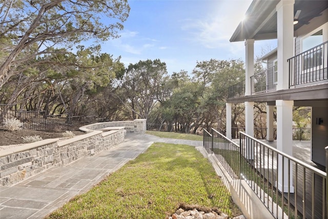 view of yard with a balcony, a patio area, and fence