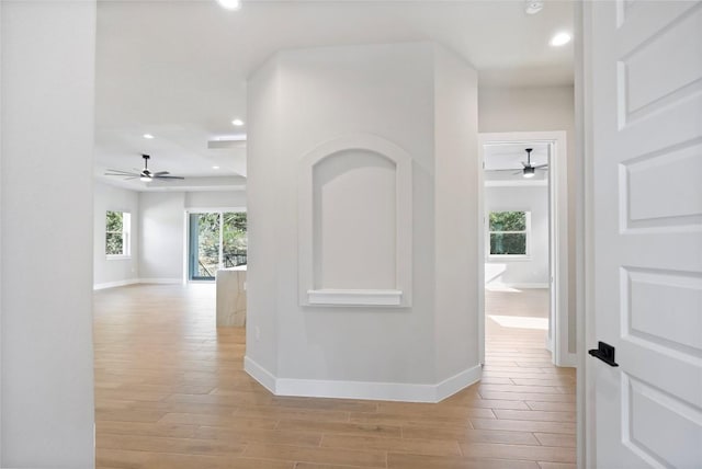 hall with recessed lighting, light wood-style flooring, and baseboards