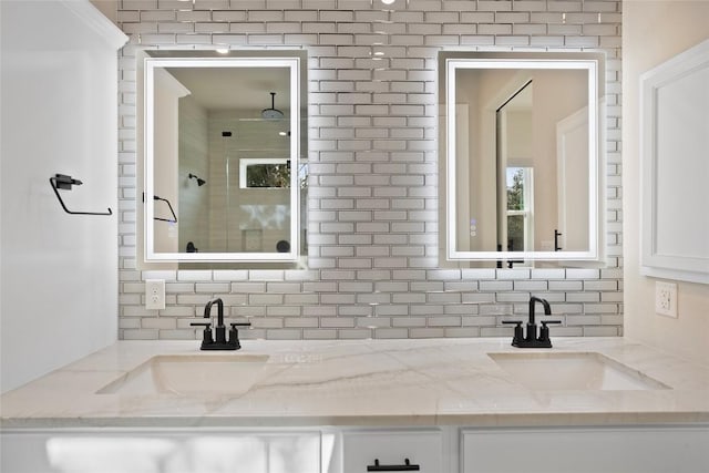 bathroom featuring tasteful backsplash, a stall shower, and a sink