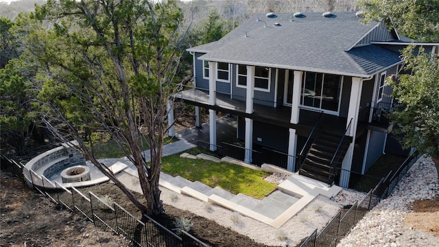 rear view of property featuring stairway, fence, a patio area, and a shingled roof