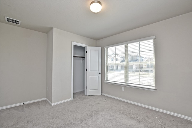 unfurnished bedroom featuring visible vents, baseboards, carpet, and a closet