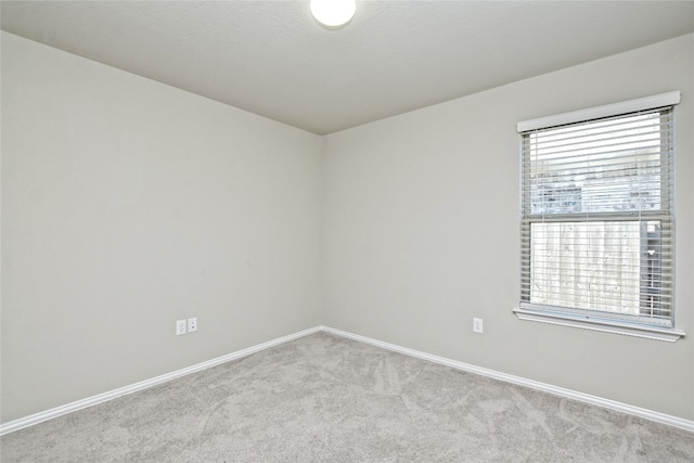 empty room with baseboards and carpet