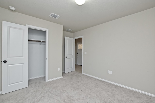 unfurnished bedroom featuring a closet, visible vents, baseboards, and carpet floors