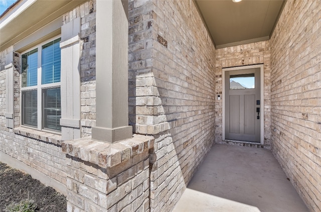 doorway to property with brick siding