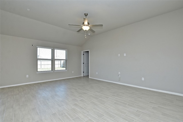 spare room with baseboards, lofted ceiling, light wood-style floors, and a ceiling fan