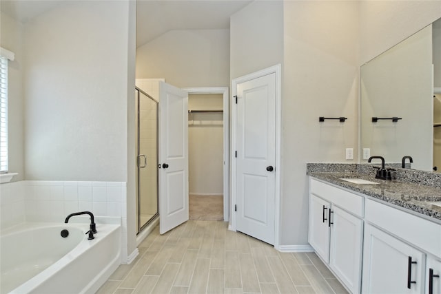 full bathroom featuring a sink, a garden tub, a spacious closet, and a shower stall