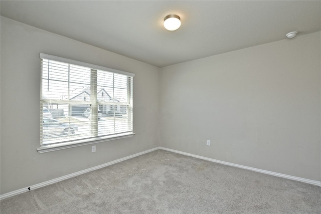 unfurnished room featuring baseboards and carpet