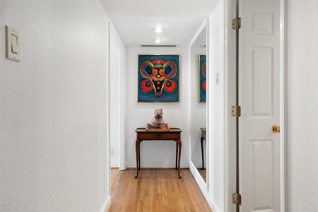 hallway featuring baseboards and light wood-style floors