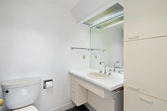 bathroom with vanity, toilet, and baseboards