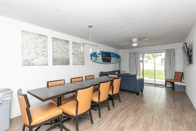 dining area featuring a textured ceiling, light wood-type flooring, and ceiling fan