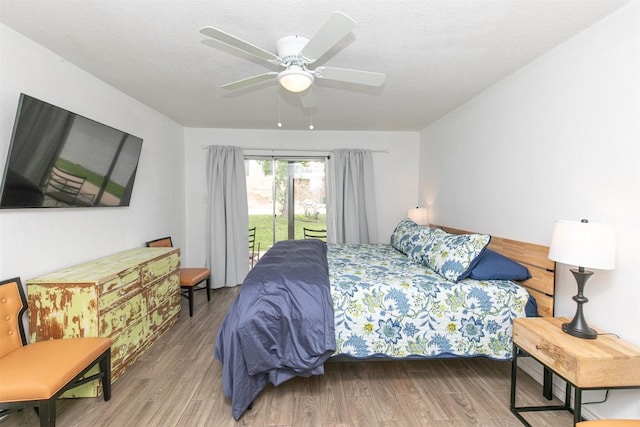 bedroom featuring a textured ceiling, access to exterior, wood finished floors, and ceiling fan