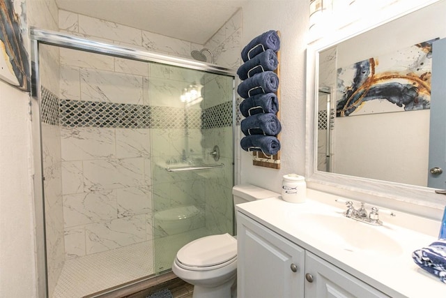 bathroom with vanity, toilet, and a shower stall