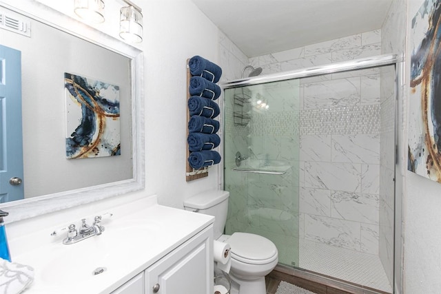 bathroom featuring visible vents, a stall shower, toilet, and vanity