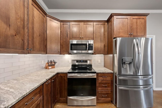 kitchen featuring crown molding, light stone countertops, tasteful backsplash, and appliances with stainless steel finishes