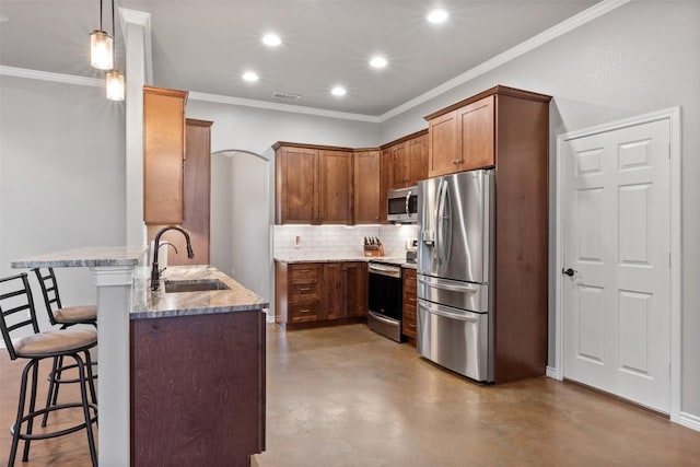 kitchen featuring a kitchen bar, visible vents, a sink, stainless steel appliances, and a peninsula