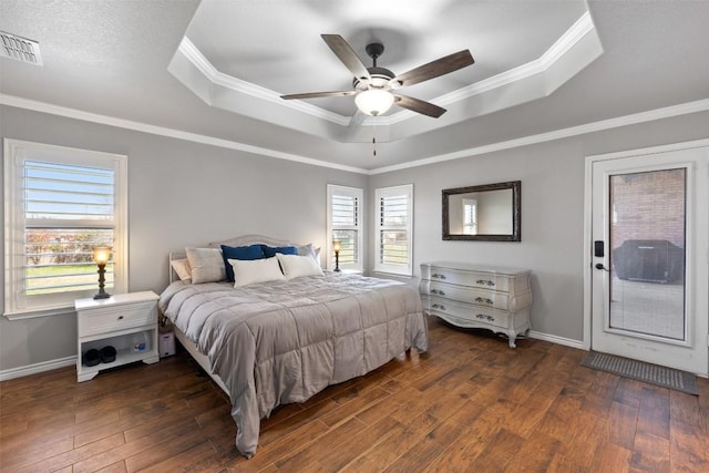 bedroom featuring visible vents, a raised ceiling, crown molding, and hardwood / wood-style flooring