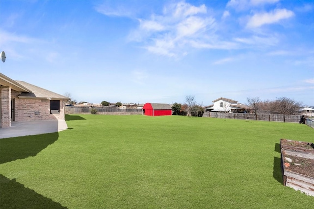 view of yard with a storage unit, a patio, an outdoor structure, and a fenced backyard