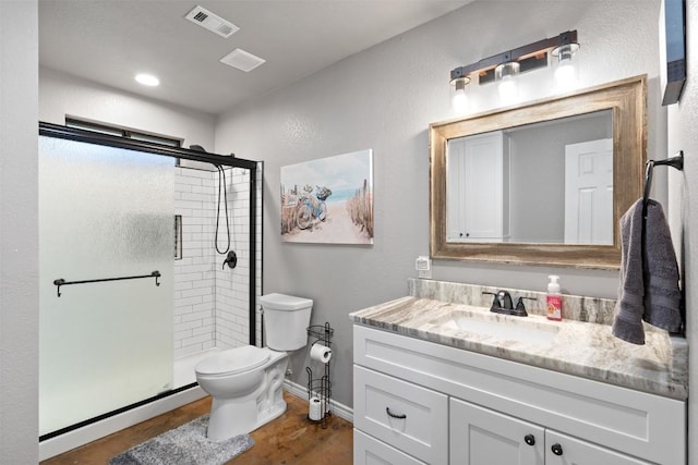 full bath with visible vents, a shower stall, toilet, and vanity