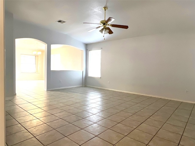 spare room with plenty of natural light, a ceiling fan, visible vents, and light tile patterned floors