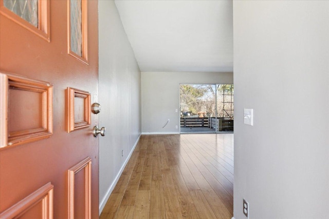 corridor featuring baseboards and wood finished floors