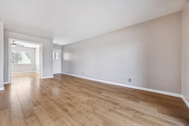 empty room with wood finished floors, baseboards, and ceiling fan