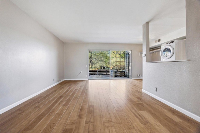 unfurnished living room with baseboards and wood finished floors