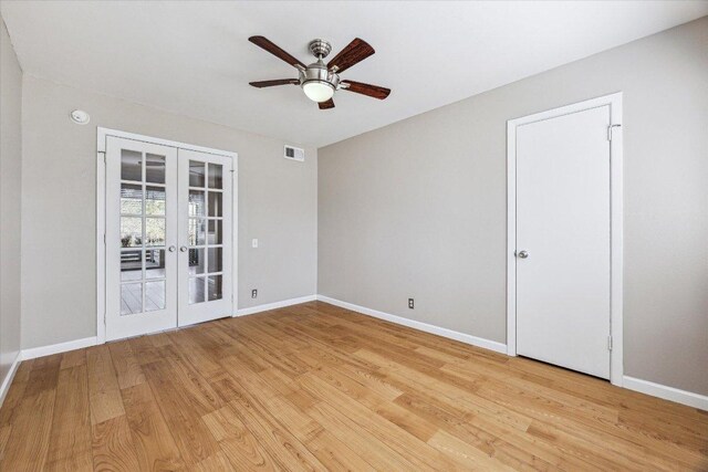 unfurnished room featuring french doors, visible vents, light wood finished floors, and baseboards