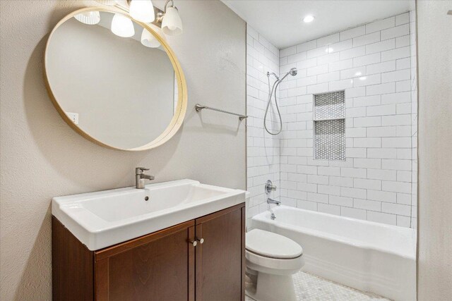 bathroom featuring vanity, shower / tub combination, and toilet