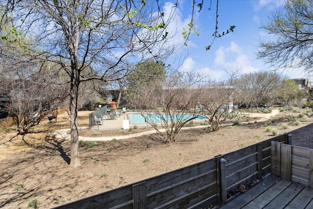 view of yard with a deck and a fenced in pool