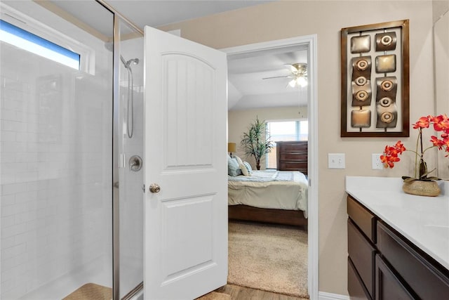 bathroom with vanity, a ceiling fan, a tile shower, and ensuite bathroom