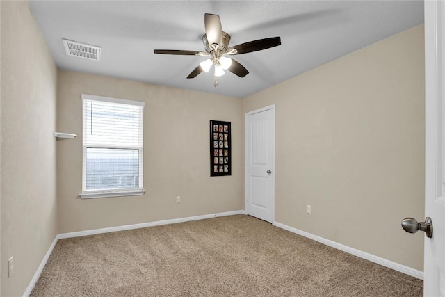 empty room featuring a ceiling fan, baseboards, visible vents, and carpet floors