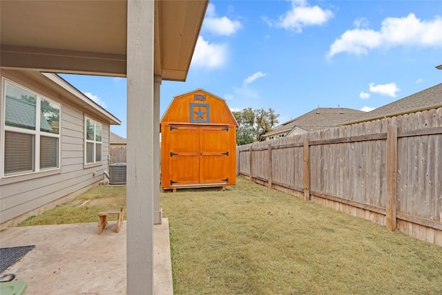 view of yard featuring an outbuilding, a fenced backyard, a shed, and a patio area