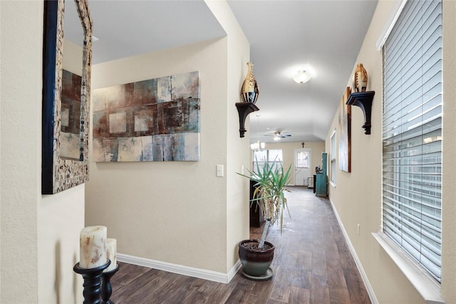 corridor featuring baseboards and wood finished floors