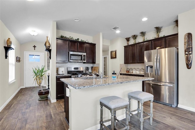 kitchen featuring visible vents, a sink, dark brown cabinets, appliances with stainless steel finishes, and tasteful backsplash