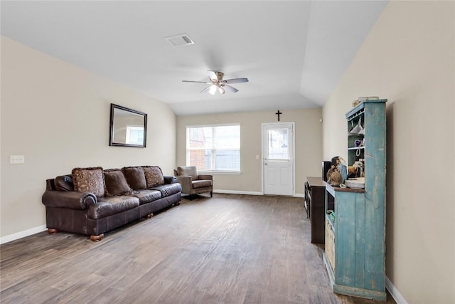 living room featuring vaulted ceiling, baseboards, ceiling fan, and wood finished floors