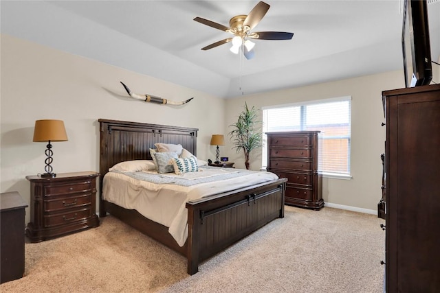 bedroom featuring a ceiling fan, vaulted ceiling, light colored carpet, and baseboards