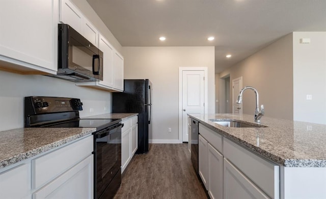 kitchen featuring a sink, black appliances, a center island with sink, and white cabinetry