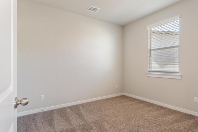 carpeted spare room with baseboards and visible vents