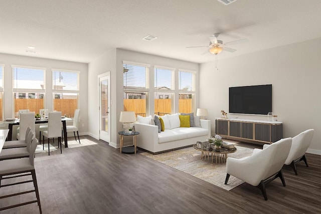 living room with baseboards, wood finished floors, visible vents, and a healthy amount of sunlight