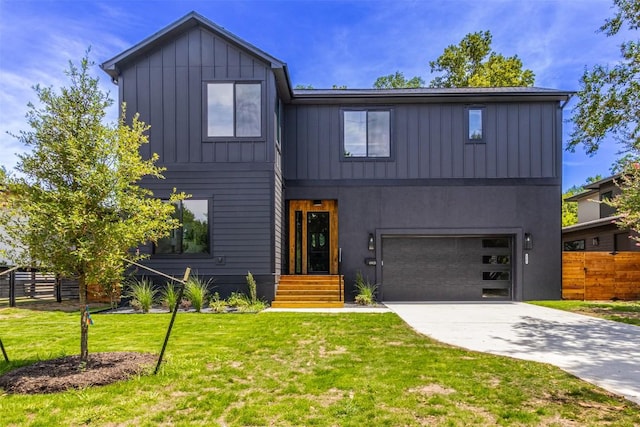 modern farmhouse style home with board and batten siding, a front yard, a garage, and fence