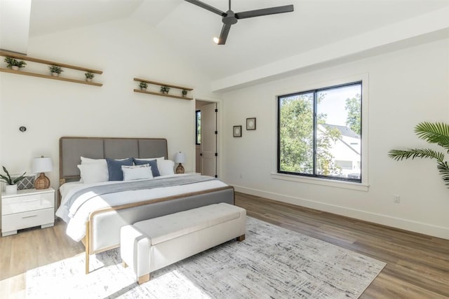 bedroom featuring baseboards, a ceiling fan, lofted ceiling, and wood finished floors