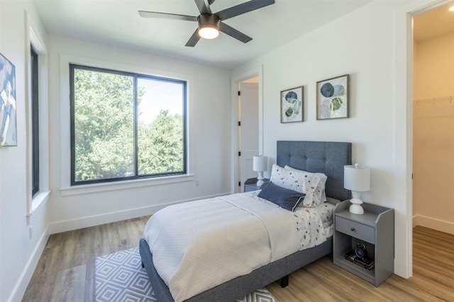 bedroom featuring light wood-style floors, baseboards, and ceiling fan