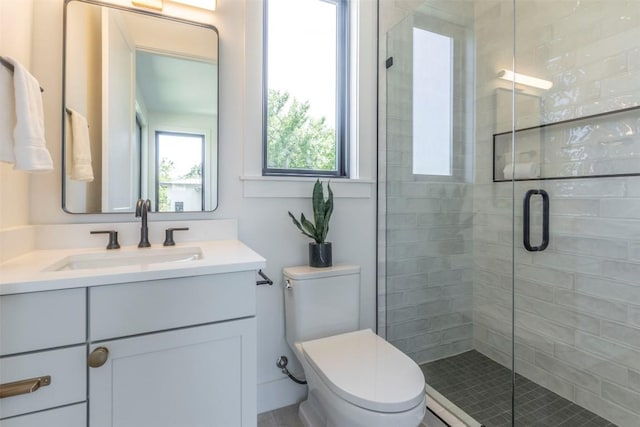 full bathroom featuring vanity, toilet, and a shower stall