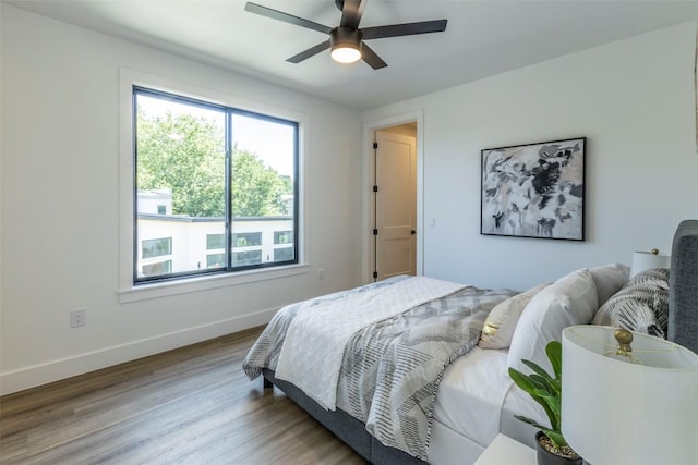 bedroom with wood finished floors, baseboards, and ceiling fan