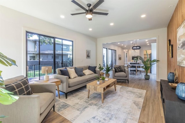 living area with recessed lighting, light wood-style flooring, and a ceiling fan