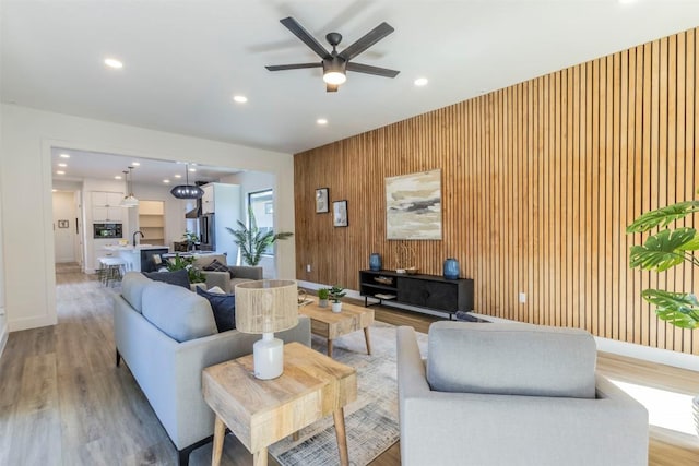 living area featuring recessed lighting, baseboards, and light wood finished floors