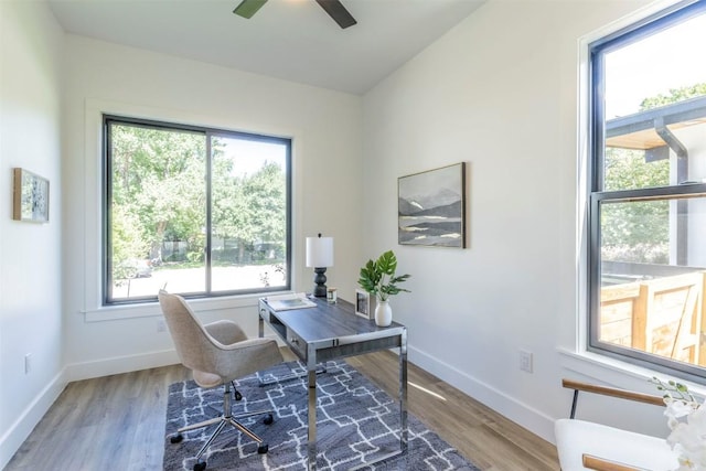 office space featuring vaulted ceiling, a ceiling fan, baseboards, and wood finished floors